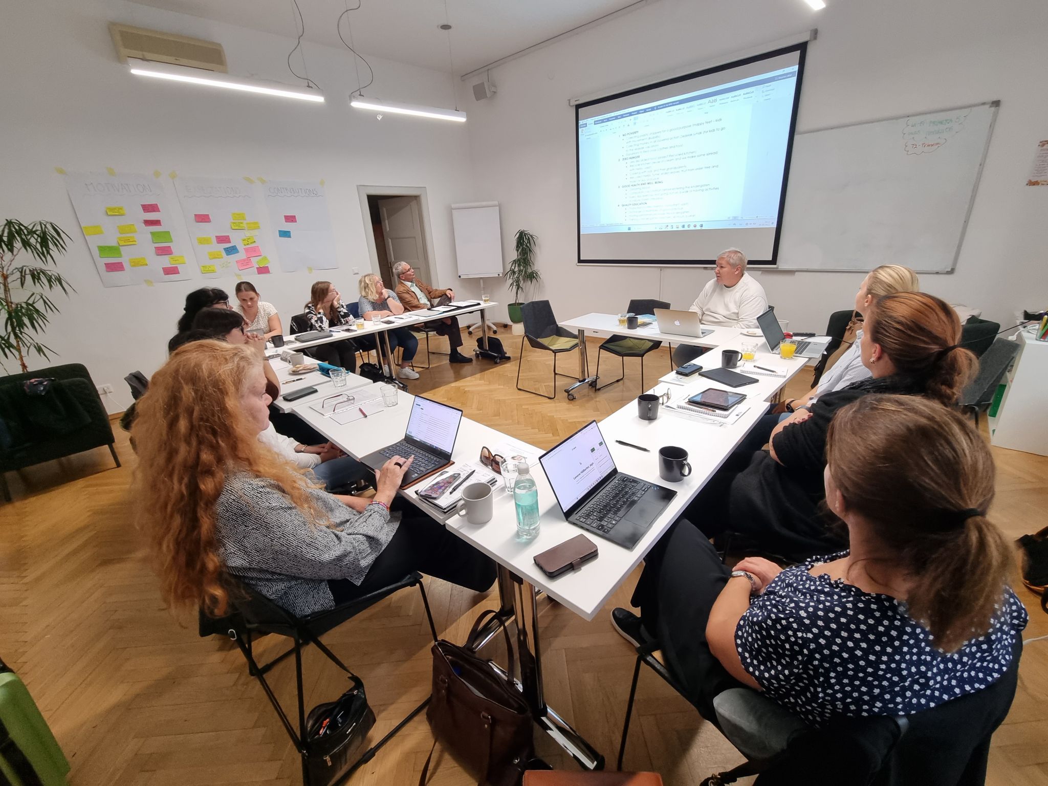 People sitting around tables during a European project meeting